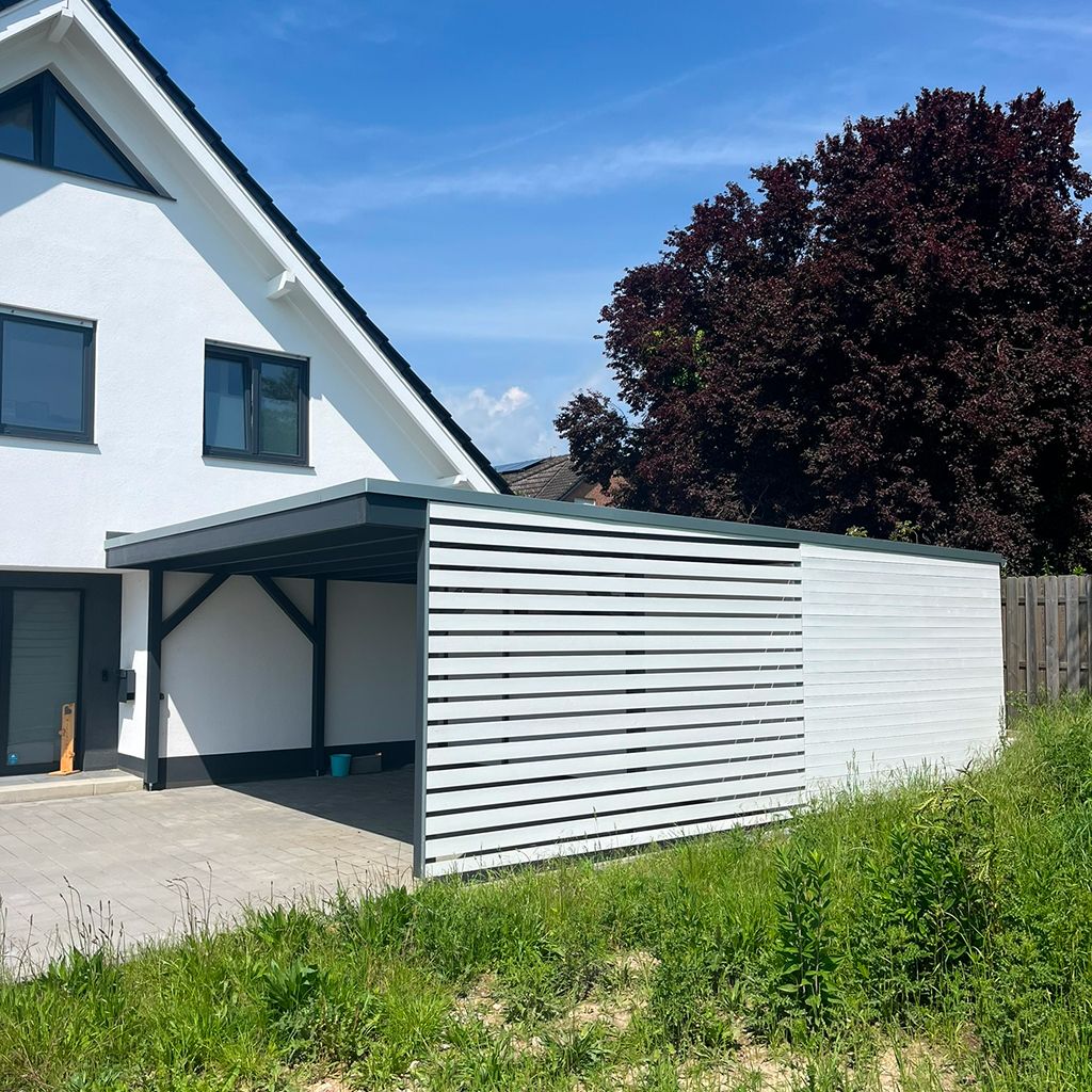 Gestreifter Carport mit grünem Rasen und Baum im Hintergrund