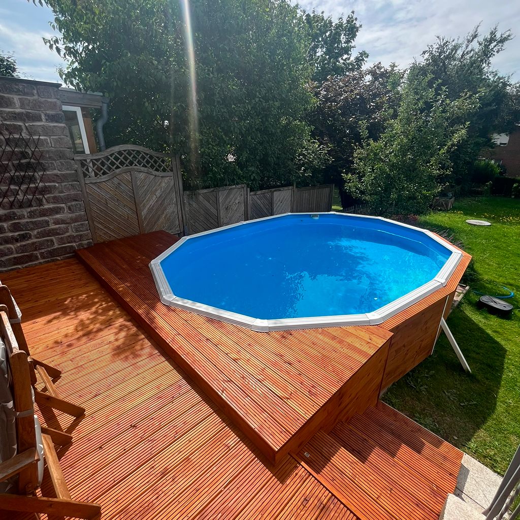 Ein schöner blauer Pool im Garten mit Holzdeck