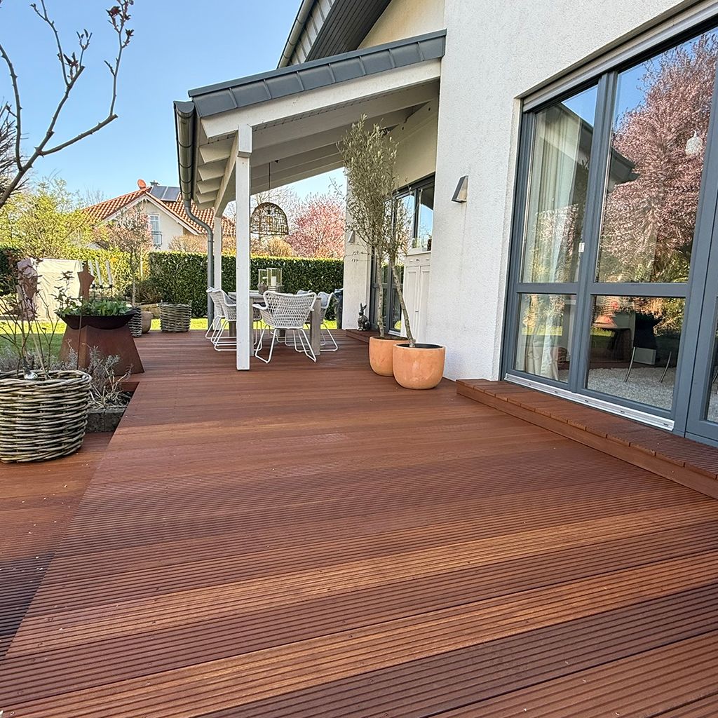 Sicht auf die Holzterrasse mit Gartenmöbeln und Pflanzen