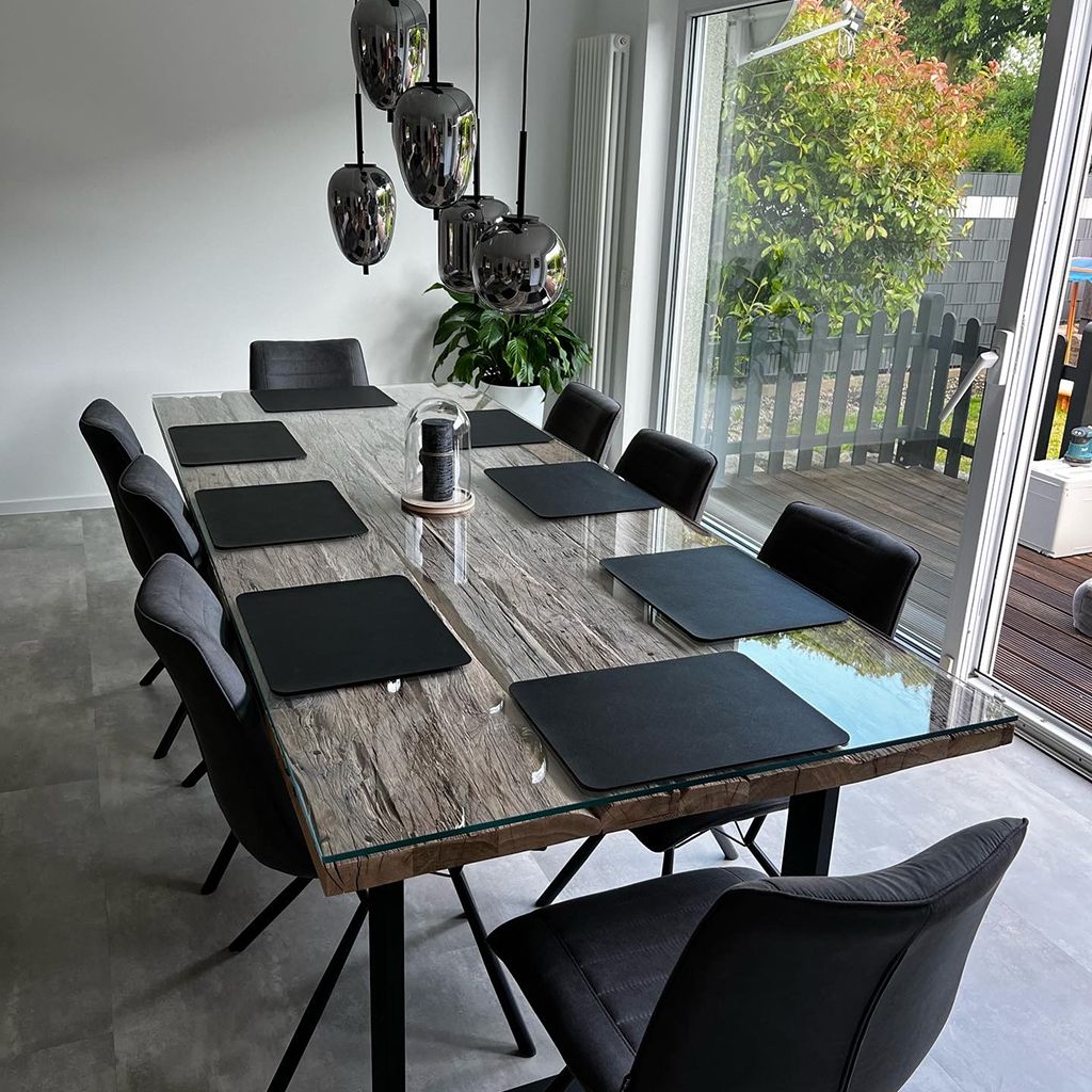 Moderner Esstisch mit schwarzen Untersetzern und eleganten Stühlen