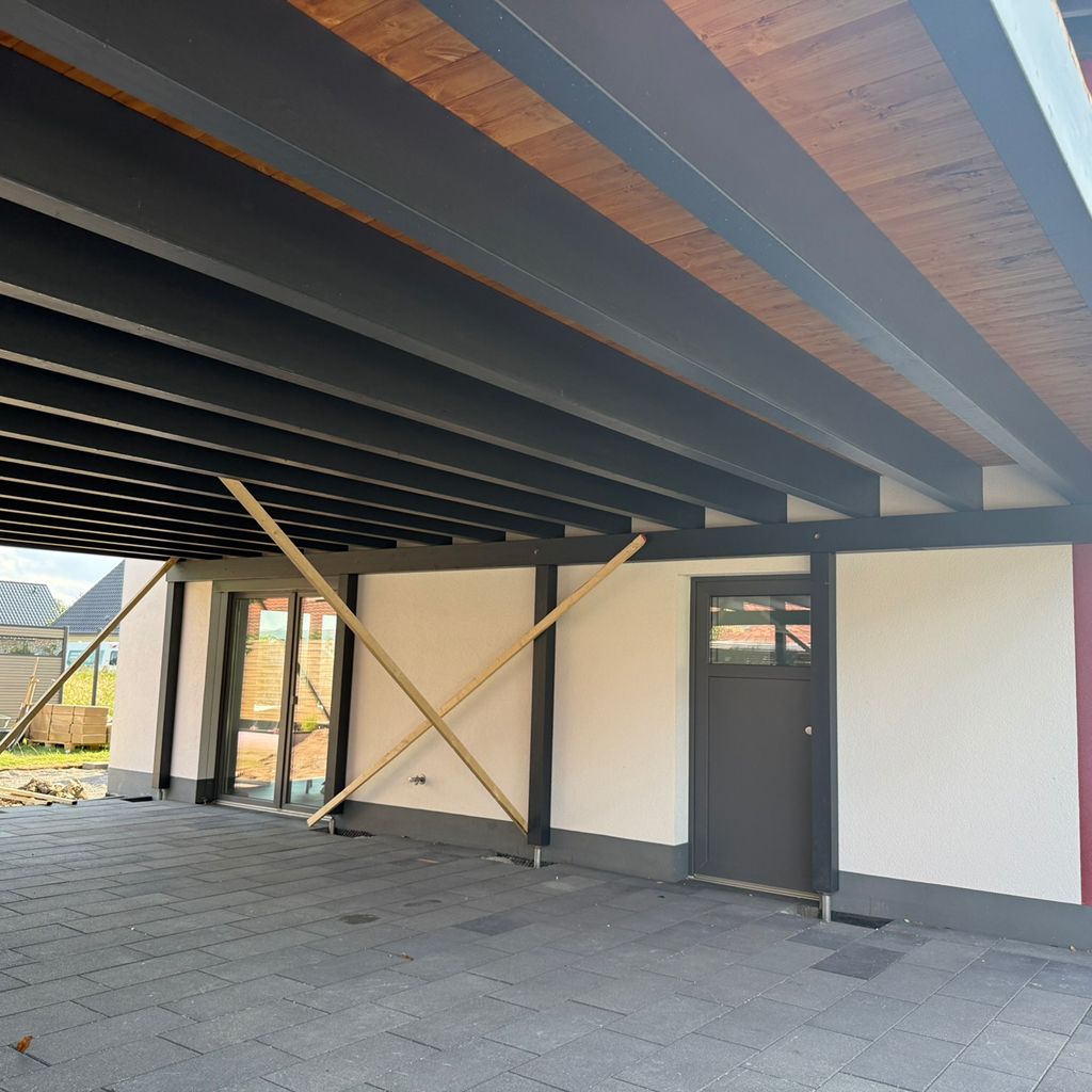 Moderne Überdachung eines Hauses mit Holz- und Stahlkonstruktion