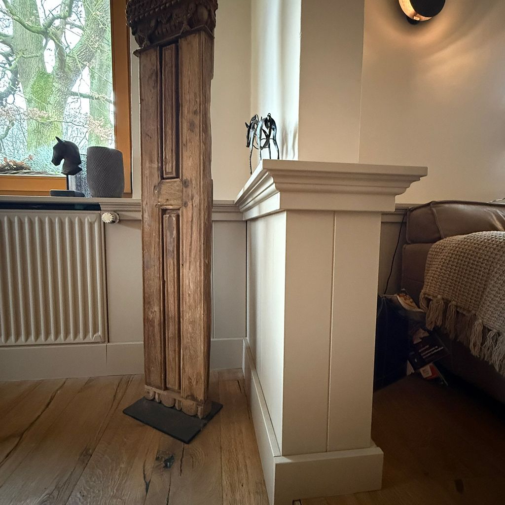 Eine rustikale Holzsäule in einem modernen Wohnzimmer.